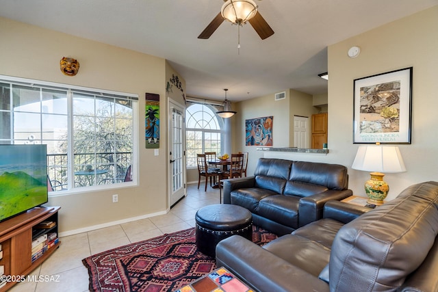 living room featuring visible vents, ceiling fan, baseboards, and light tile patterned floors