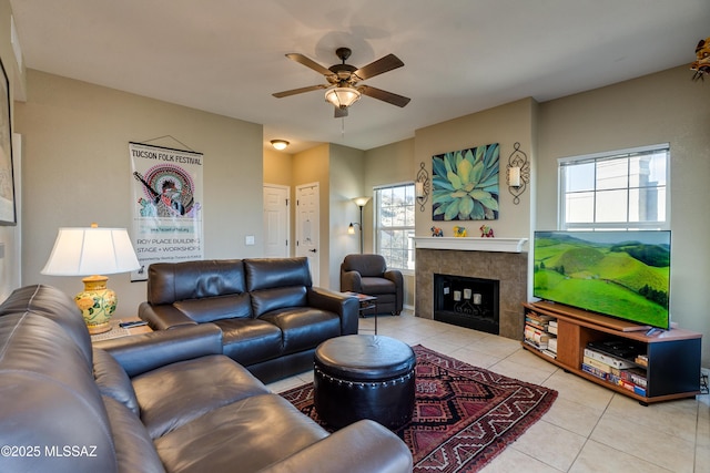 living room featuring light tile patterned floors, a fireplace, and a ceiling fan