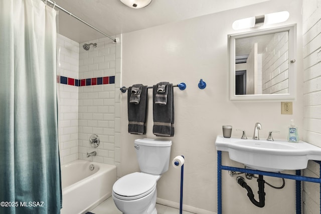 bathroom featuring shower / tub combo, baseboards, a sink, and toilet