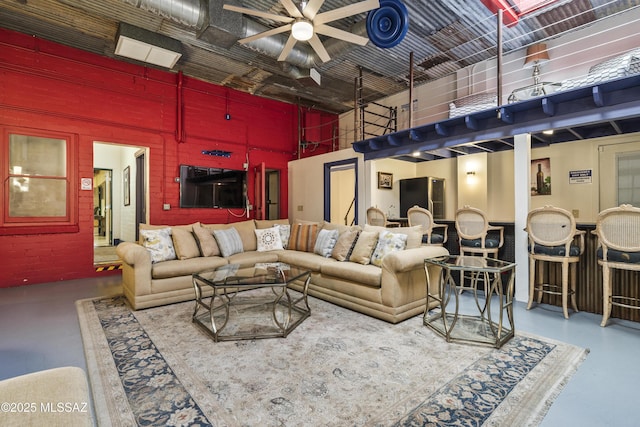 living area with concrete floors and a towering ceiling