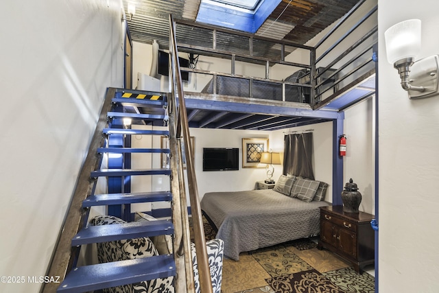 bedroom with a skylight and wood finished floors