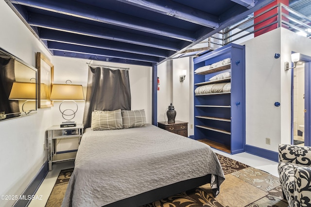 bedroom featuring beam ceiling and baseboards