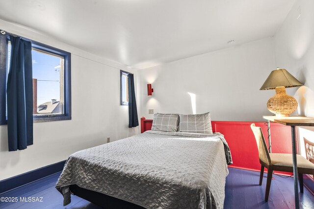 bedroom featuring baseboards and wood finished floors