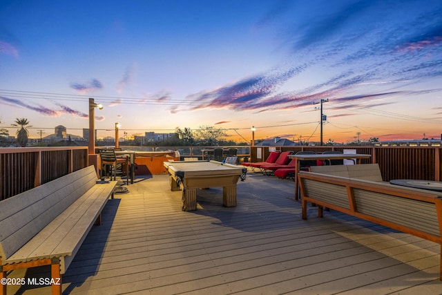 deck at dusk featuring a covered hot tub