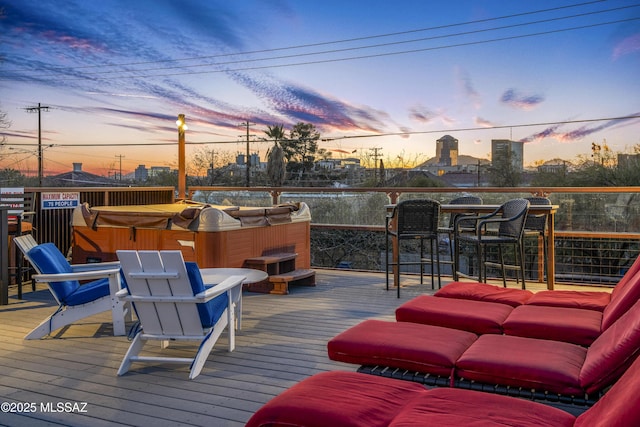 deck at dusk with a hot tub