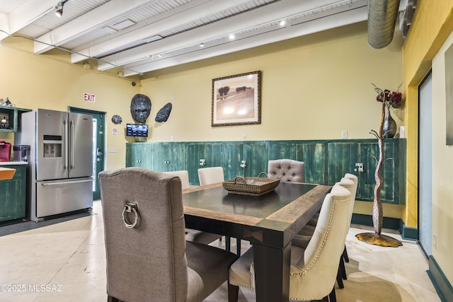 dining space with beamed ceiling and rail lighting