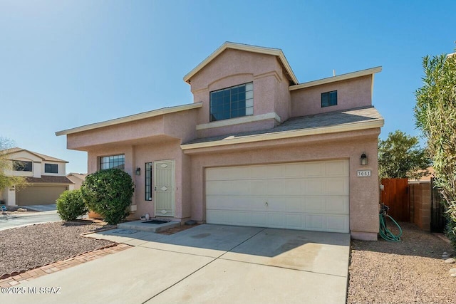 traditional-style house with stucco siding, driveway, a garage, and fence