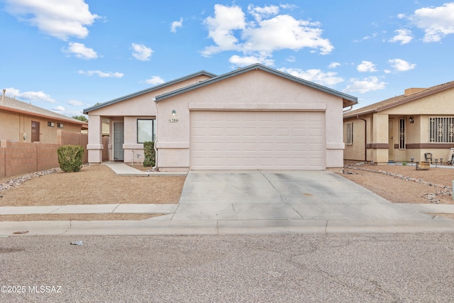 ranch-style home featuring a garage, fence, driveway, and stucco siding