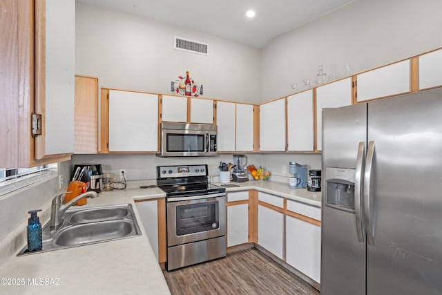kitchen featuring visible vents, stainless steel appliances, a sink, and light countertops