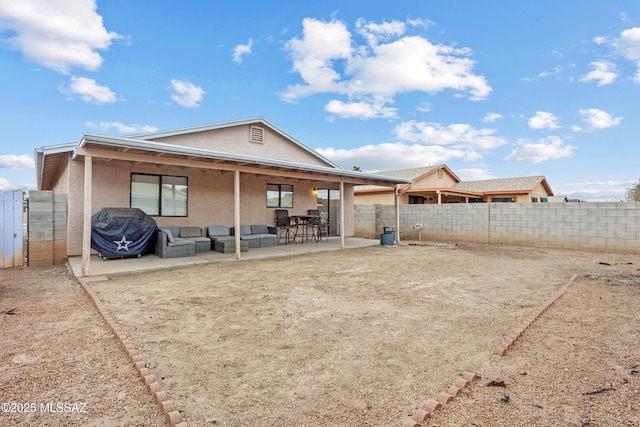 back of house featuring outdoor lounge area, a patio, a fenced backyard, and stucco siding