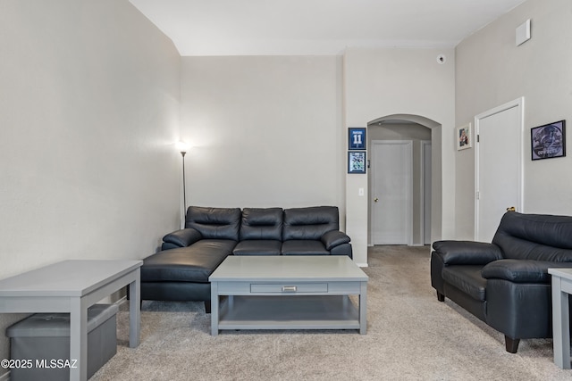 carpeted living area with arched walkways