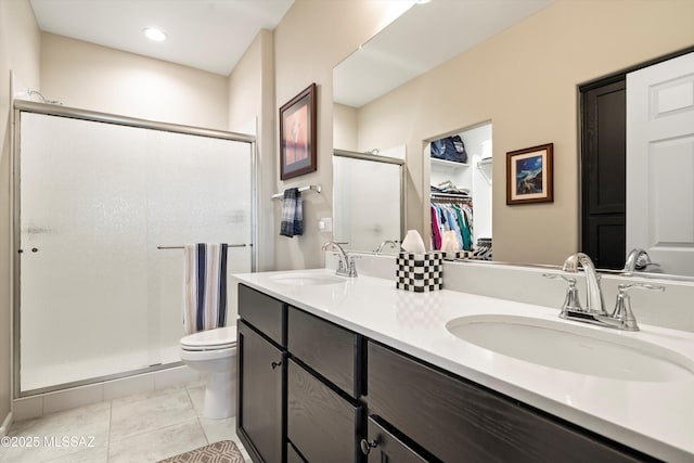 full bathroom featuring tile patterned flooring, toilet, a stall shower, and a sink