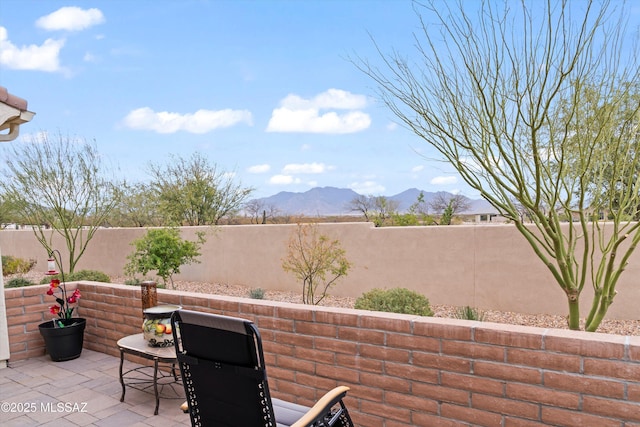 view of patio featuring a mountain view and a fenced backyard