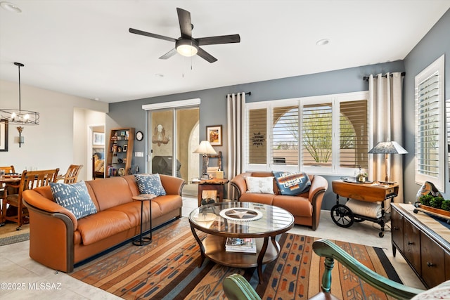 living area with ceiling fan with notable chandelier