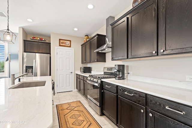 kitchen featuring a sink, stainless steel appliances, light countertops, decorative light fixtures, and wall chimney exhaust hood