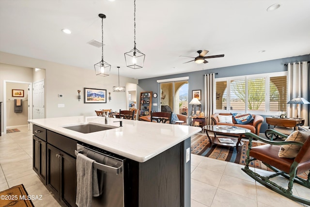 kitchen featuring stainless steel dishwasher, open floor plan, light countertops, light tile patterned floors, and a healthy amount of sunlight
