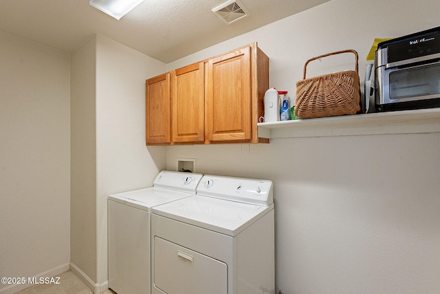 laundry area featuring cabinet space, baseboards, visible vents, and washer and clothes dryer