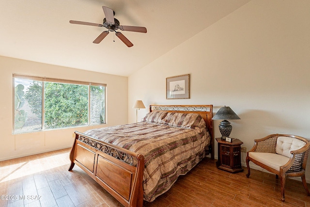 bedroom with ceiling fan, vaulted ceiling, and wood finished floors