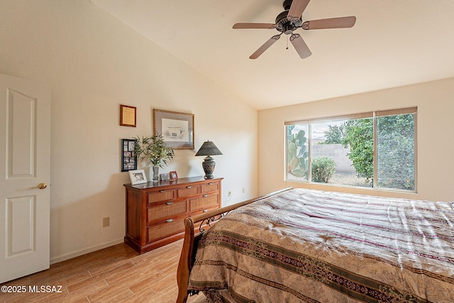 bedroom with lofted ceiling, light wood-style flooring, and baseboards