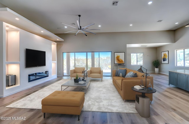 living room featuring a ceiling fan, visible vents, light wood-style flooring, and recessed lighting
