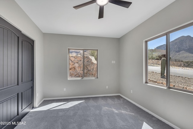 unfurnished bedroom with a ceiling fan, baseboards, and carpet floors