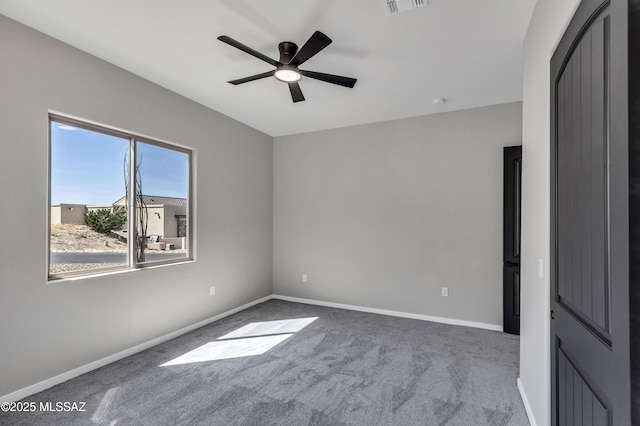 carpeted empty room featuring baseboards, ceiling fan, and visible vents