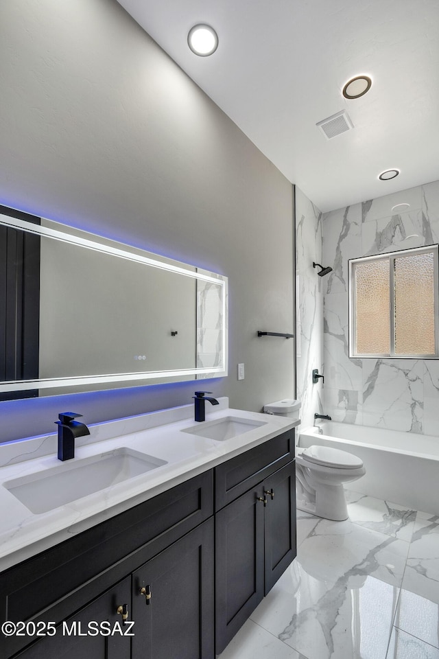 full bath featuring double vanity, marble finish floor, washtub / shower combination, and a sink