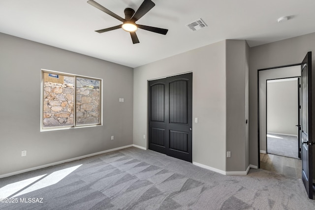 unfurnished bedroom with visible vents, a ceiling fan, carpet, and baseboards