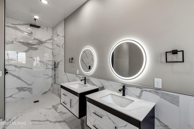 bathroom featuring two vanities, a marble finish shower, and a sink