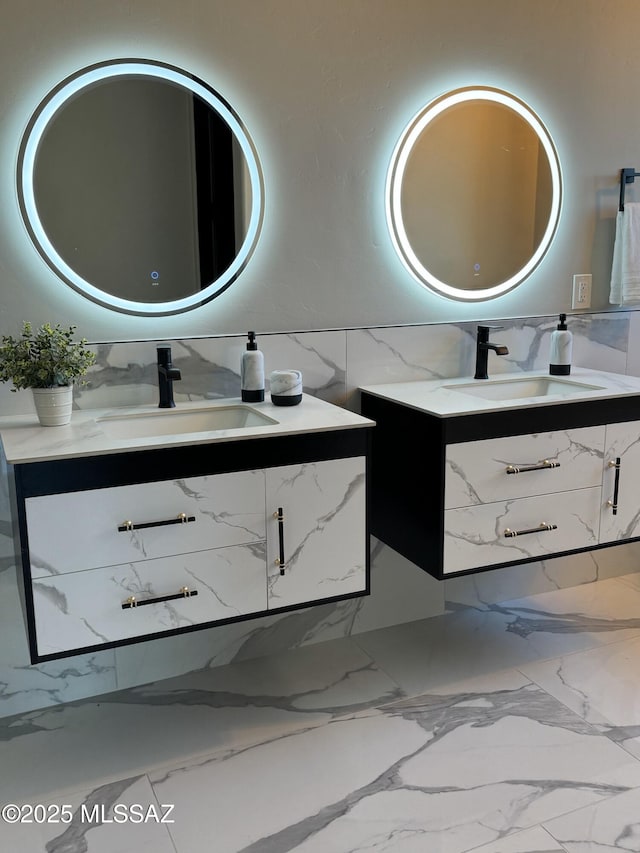 bathroom with a sink, tile walls, two vanities, and marble finish floor