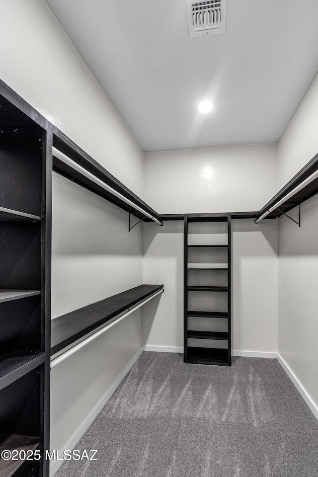 walk in closet featuring visible vents and dark carpet