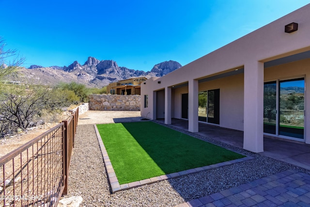 view of yard featuring a mountain view, a patio, and fence