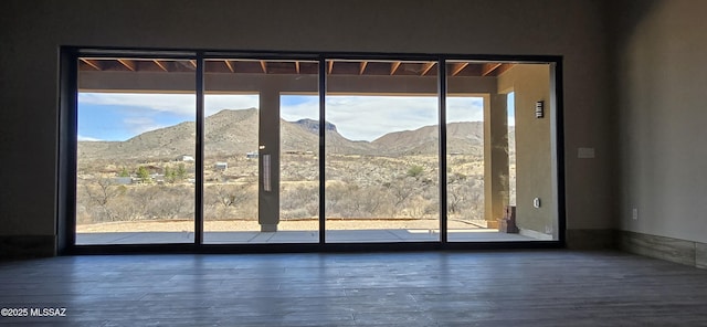 doorway to outside featuring a mountain view, a wealth of natural light, and wood finished floors