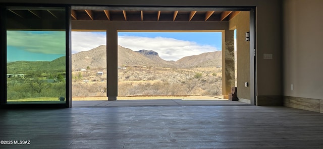 entryway with a healthy amount of sunlight, a mountain view, and wood finished floors