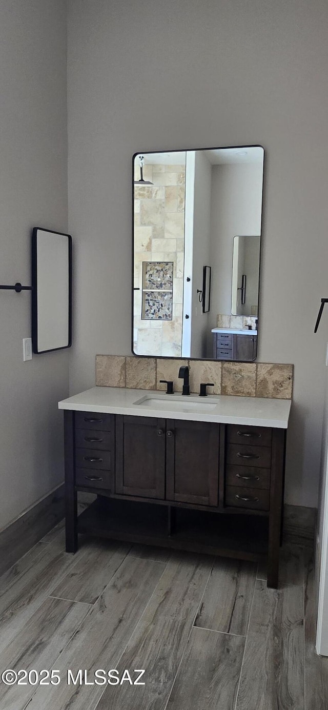 bathroom featuring baseboards, wood finished floors, and vanity