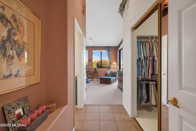 hall with light carpet and light tile patterned flooring