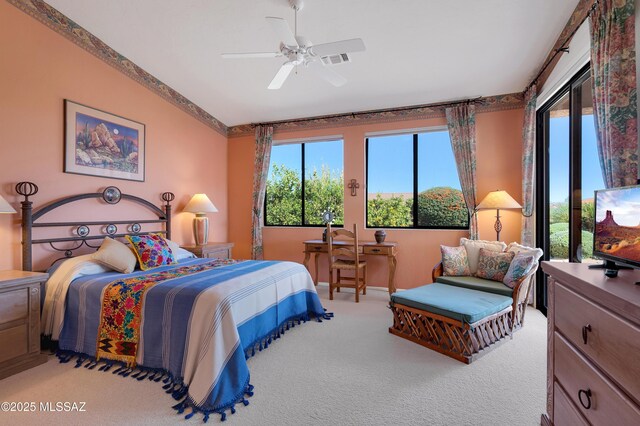 carpeted bedroom with lofted ceiling, visible vents, and ceiling fan