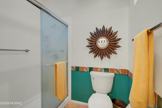 full bathroom featuring tile patterned flooring, a shower stall, and toilet