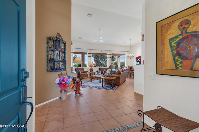 tiled foyer entrance featuring visible vents, baseboards, and ceiling fan with notable chandelier