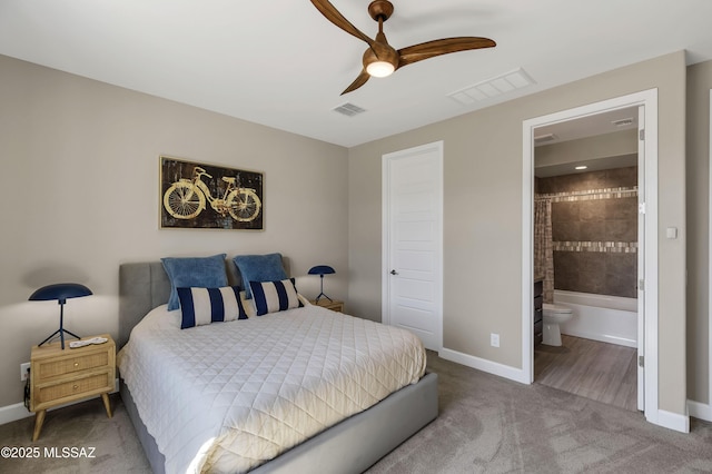 bedroom with ensuite bath, carpet flooring, baseboards, and visible vents