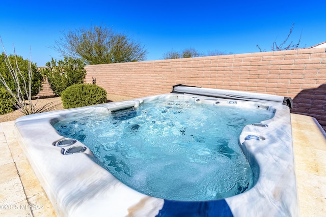 view of pool featuring an outdoor hot tub and a fenced backyard