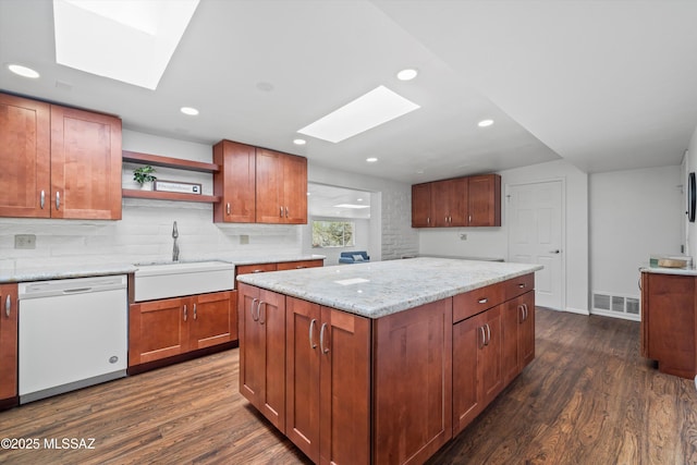 kitchen with a sink, visible vents, a skylight, and white dishwasher