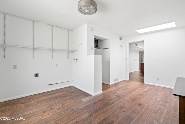 spare room featuring visible vents, wood finished floors, baseboards, and a skylight