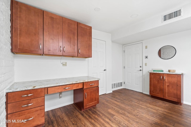 unfurnished office featuring baseboards, visible vents, dark wood-style flooring, and built in study area