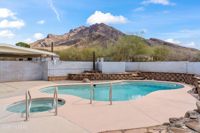 view of swimming pool featuring a fenced in pool, a patio, a fenced backyard, a mountain view, and an in ground hot tub