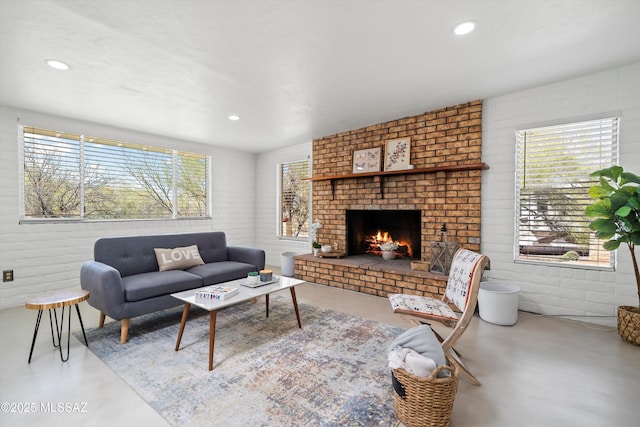 living room with finished concrete floors, recessed lighting, and a fireplace