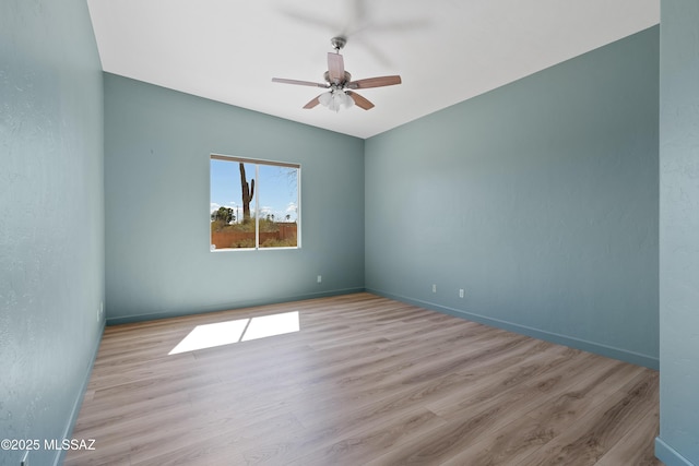 unfurnished room featuring wood finished floors, baseboards, and ceiling fan