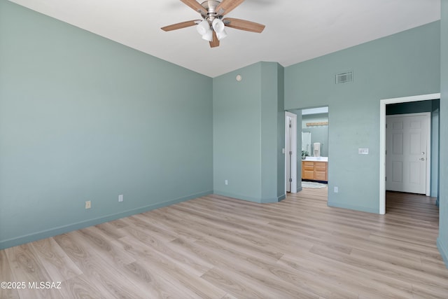 unfurnished bedroom featuring visible vents, baseboards, light wood-type flooring, ensuite bathroom, and a ceiling fan