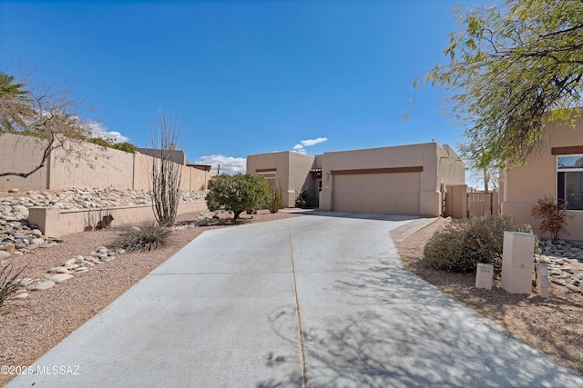 view of front facade featuring stucco siding, concrete driveway, a garage, and fence