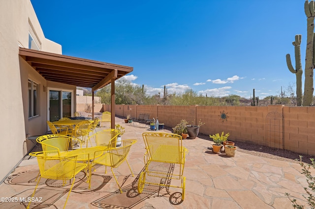 view of patio with outdoor dining space and a fenced backyard